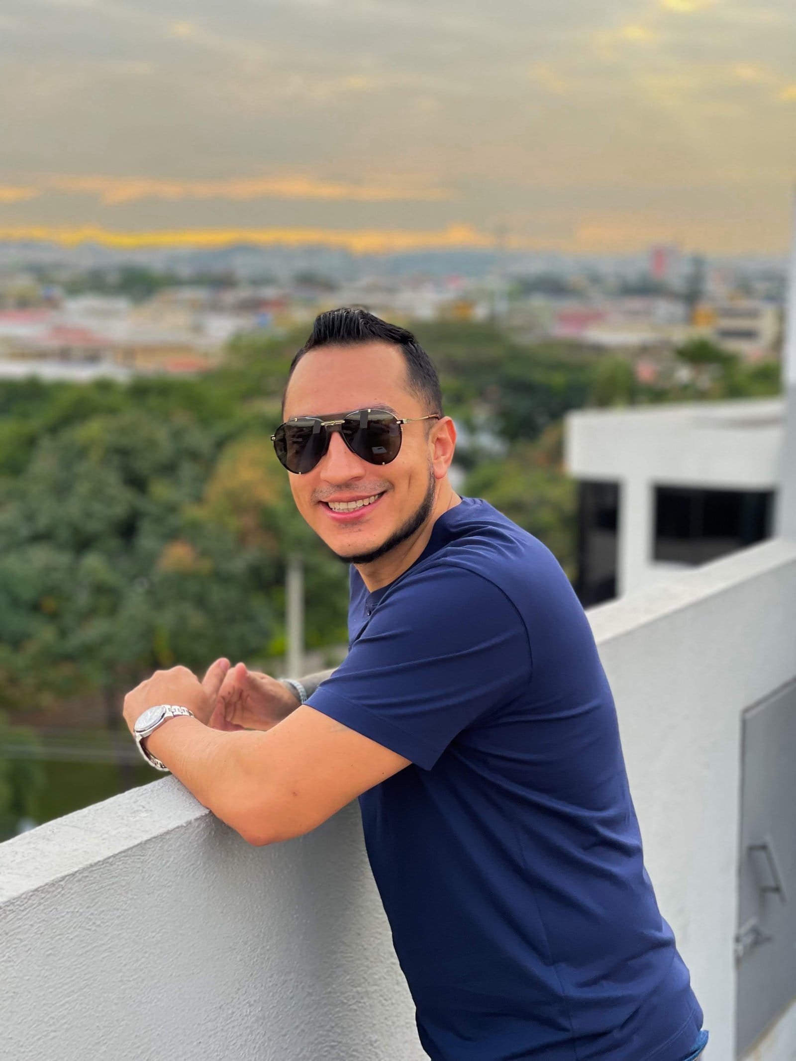 Rafael Ortega en rooftop al atardecer con vista panorámica de la ciudad