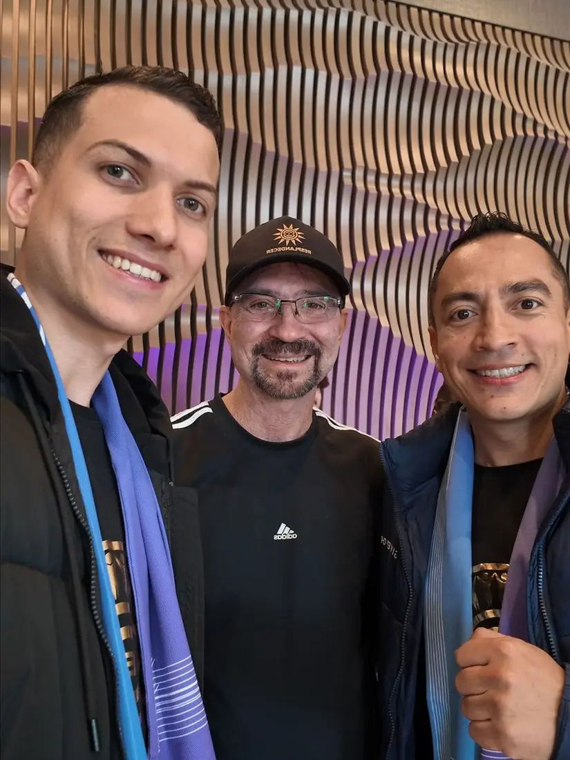Líderes en Evento Oficial Celebración de Éxito 4Life - Tres hombres con lanyards de evento en interior moderno - Expansión Internacional
