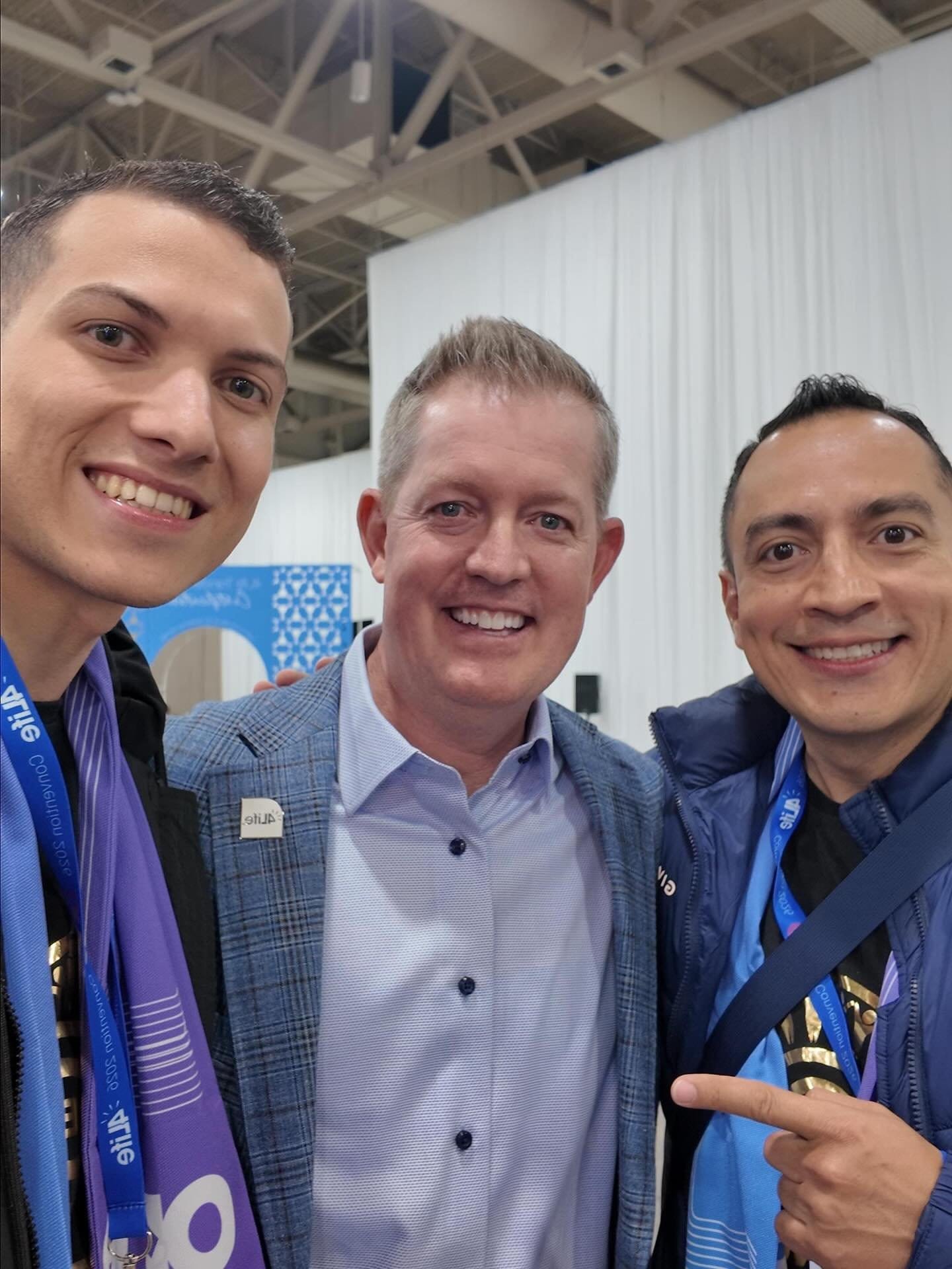 Cumbre de Negocios Galería de Éxito 4Life - Tres hombres con lanyards de evento techo industrial - Mentoría Global