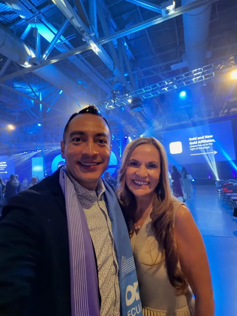 Gala de Reconocimiento Evento de Logros 4Life - Hombre y mujer en evento con iluminación azul ambiente profesional - Expansión Internacional