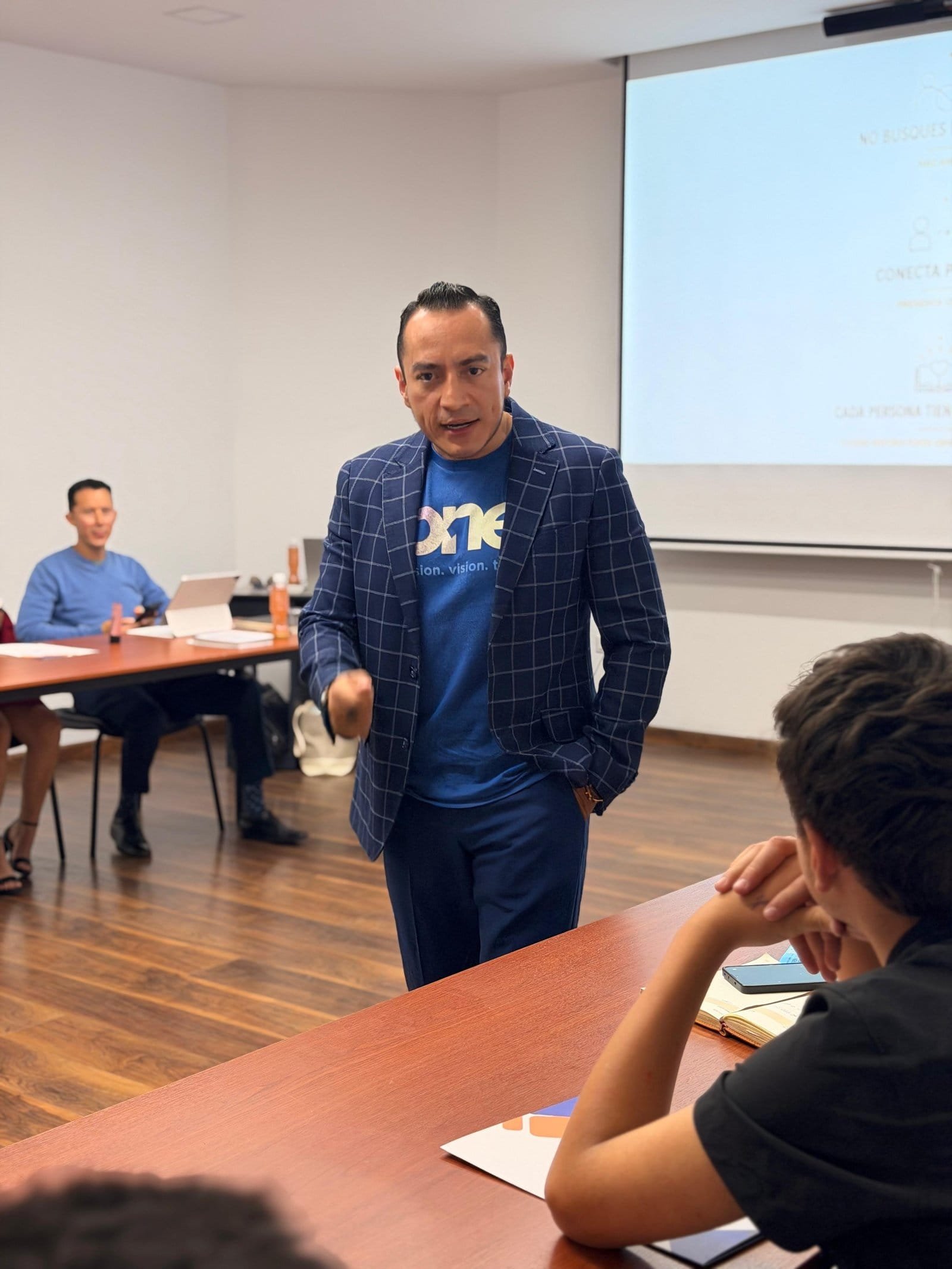 Rafael Ortega impartiendo sesión de formación en sala de capacitación con proyector y asistentes