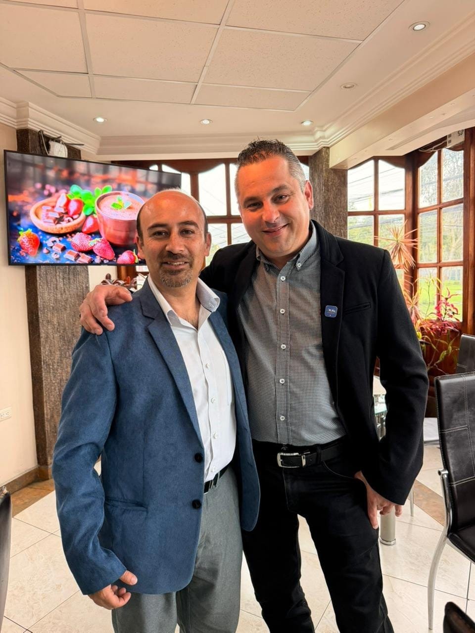 Logro de Metas en Equipo Celebración de Éxito 4Life - 2 hombres en interiores con gesto de éxito - Mentoría Global