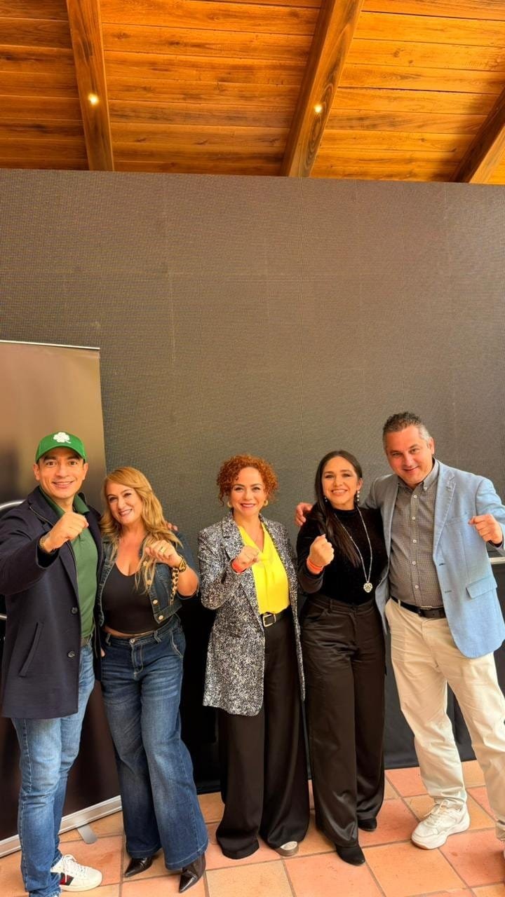 Celebrando Nuevos Rangos Galería de Éxito 4Life - Cinco personas en interiores con plantas puños en alto - Mentoría Global